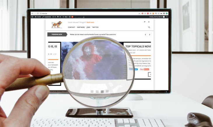 Een internetgebruiker kijkt met een vergrootglas naar de website van VLCM.